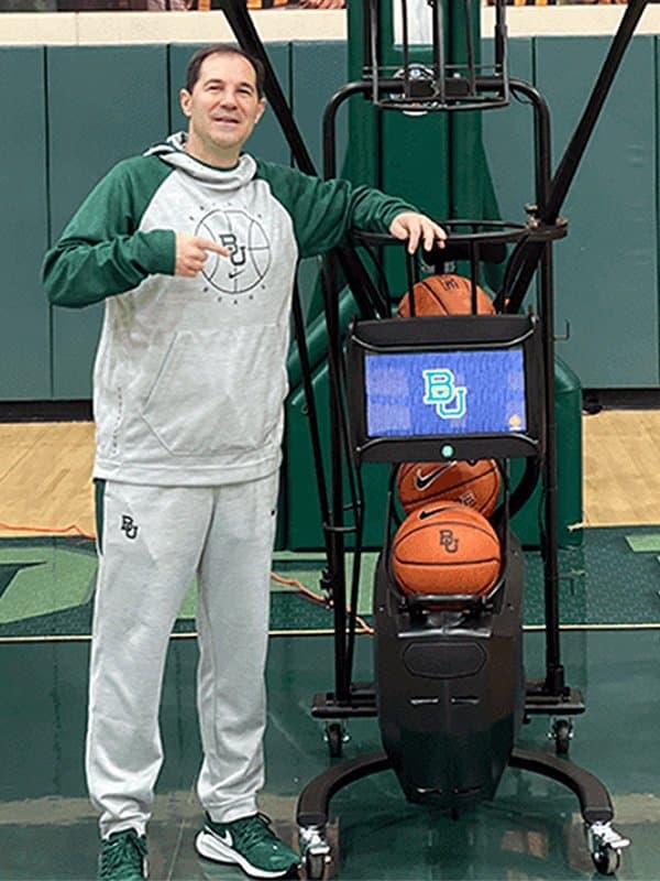 Scott Drew, Head Coach, Baylor Men's Basketball, alongside a Dr. Dish shooting machine